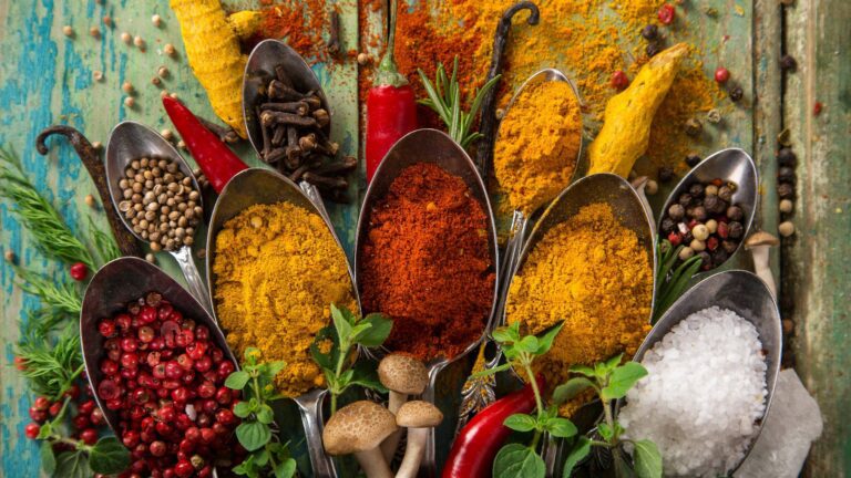 Various colorful spices on wooden table, top view.