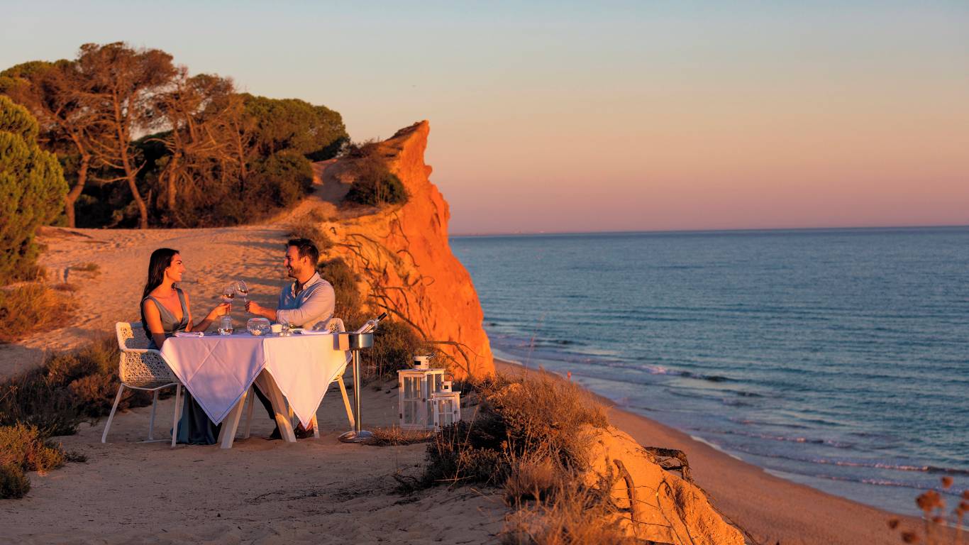 Couple having romantic dinner outside by the sea