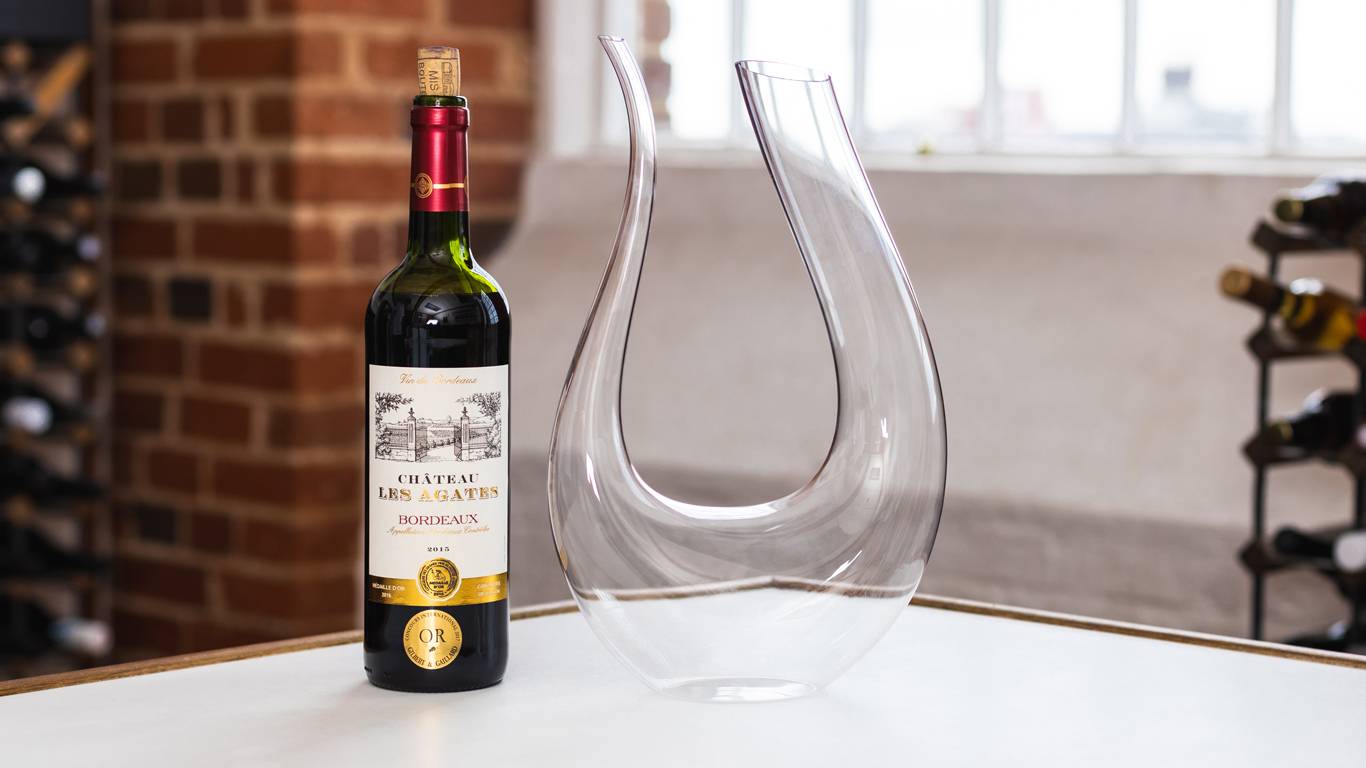 Bottle of red wine next to a wine decanter