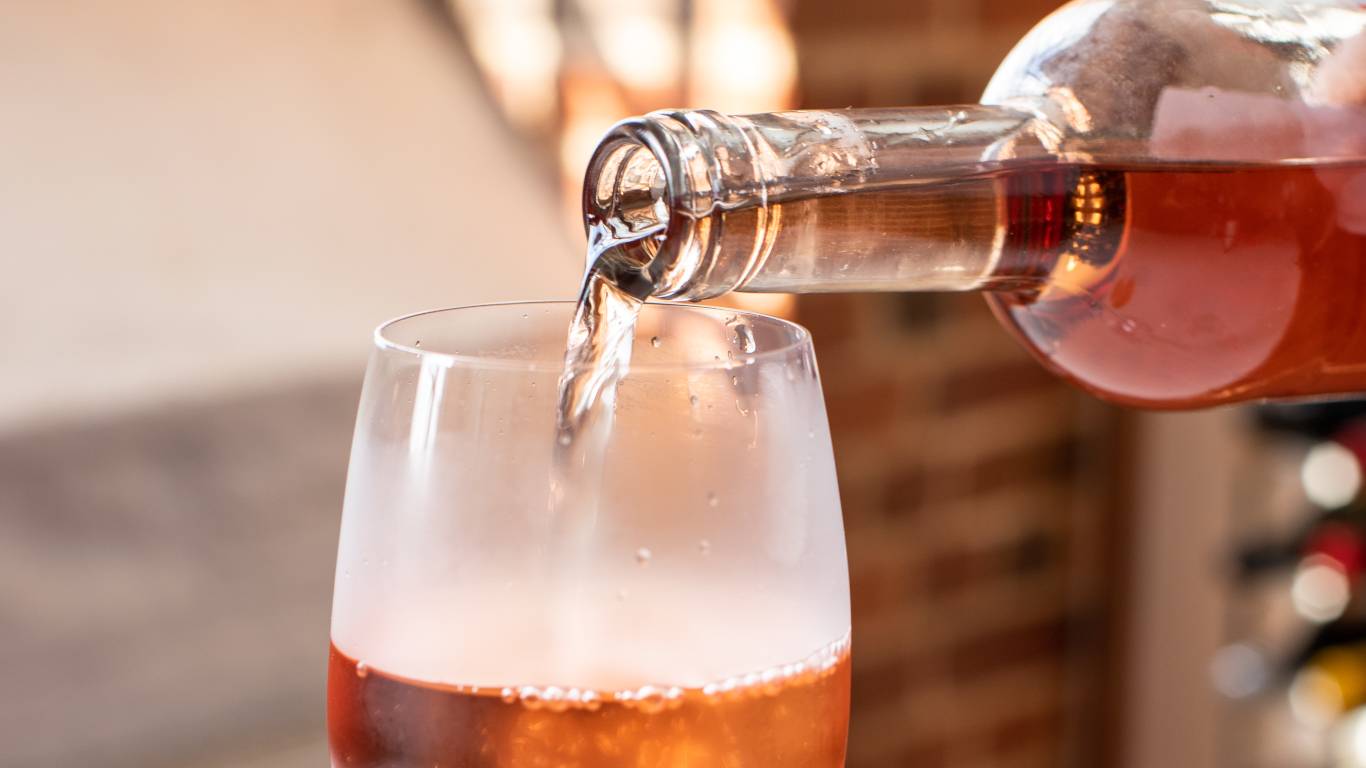 Rose wine being poured from a bottle into a glass