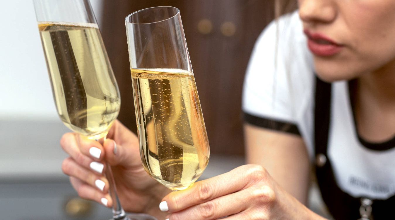 Girl comparing bubbles in a glass of Prosecco with bubbles in a glass of Champagne