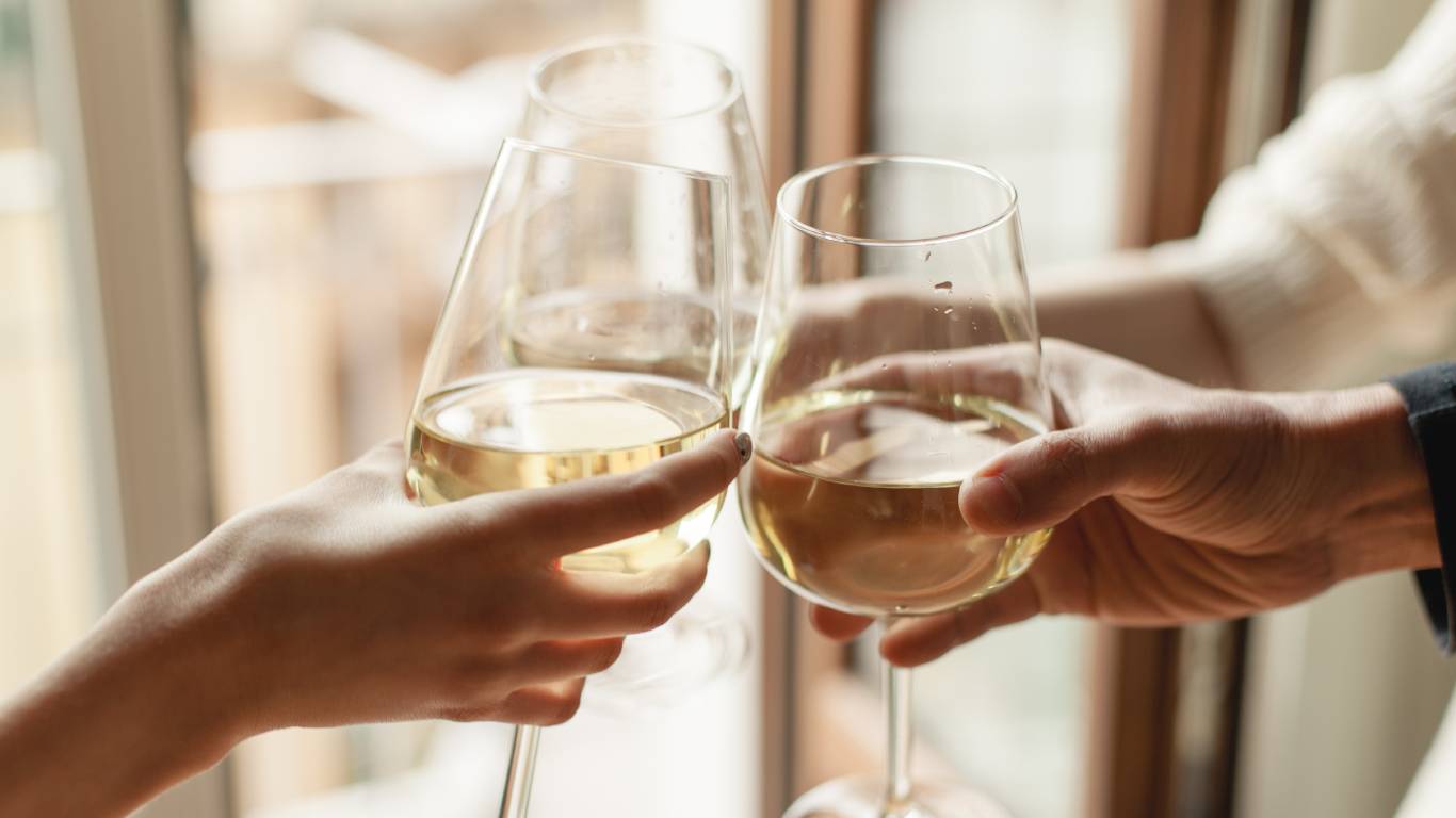 People toasting with glasses of white wine