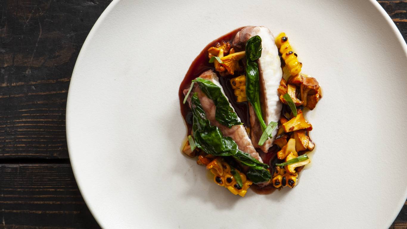 Red wine-poached monkfish with corn, girolles and black garlic