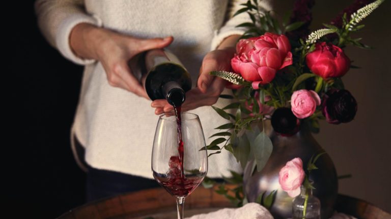 Woman pouring Rioja red wine into a glass
