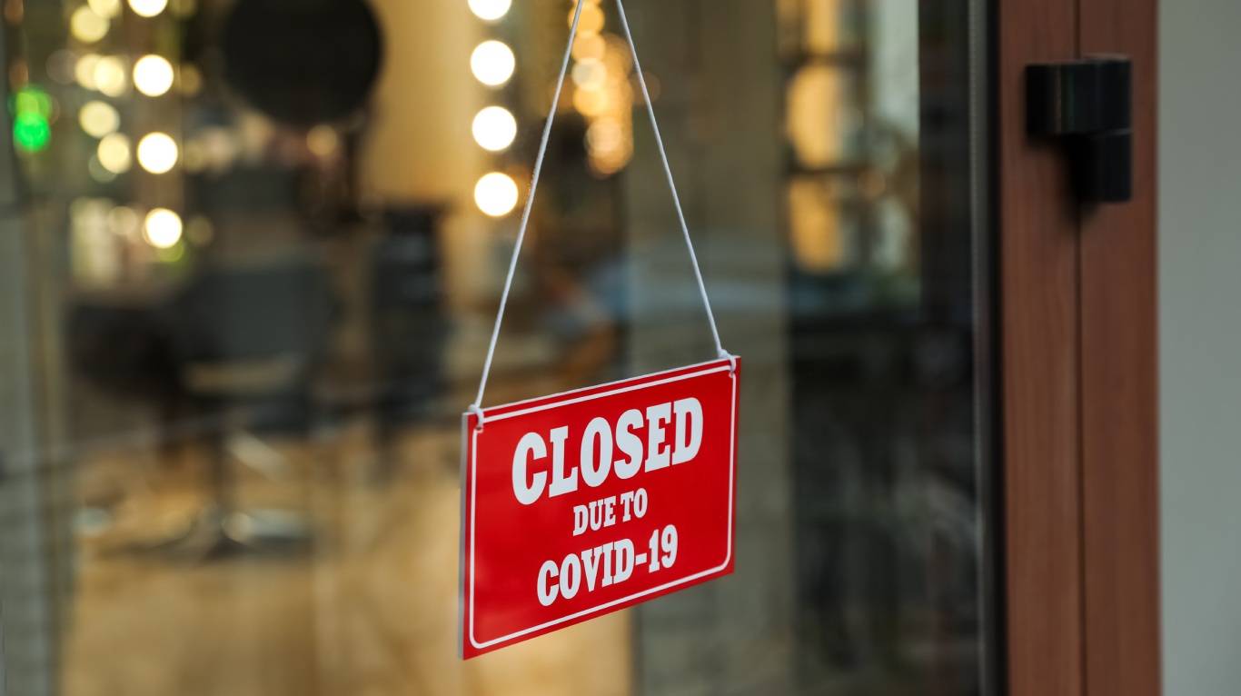 Sign hanging on shop door saying closed due to covid-19