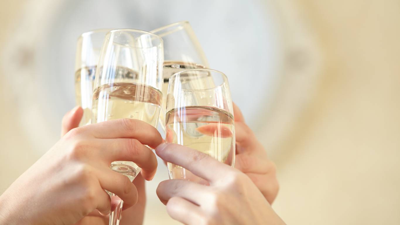 Four people toasting with flutes of Champagne