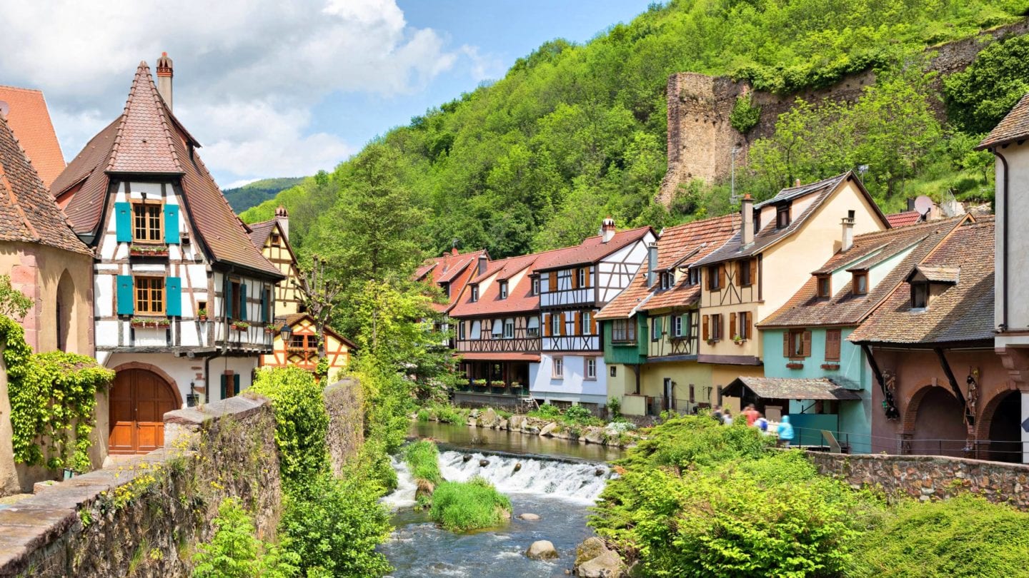 French traditional half-timbered houses and La Weiss river in Kayserberg village in Alsace, France