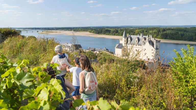 Family walking along the Loire river by a chateau