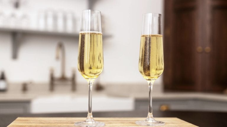 Two flute glasses of Prosecco on a kitchen worktop