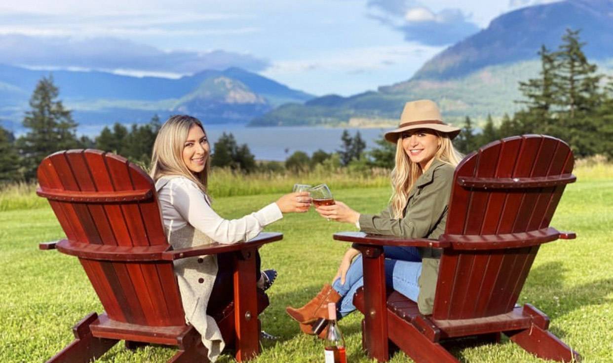 Two women drinking rose wine outside in Washington overlooking the river