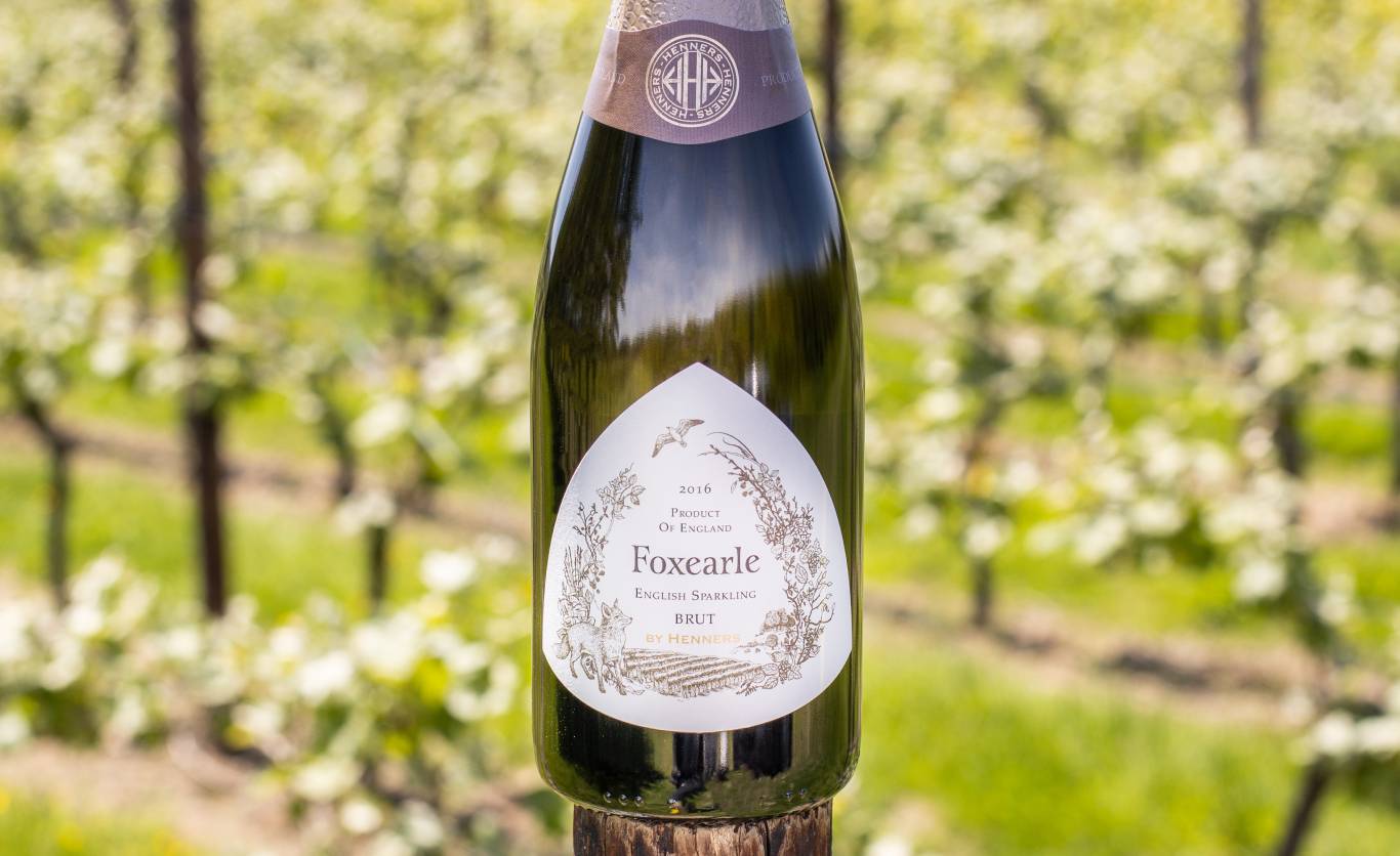 Closeup of Henners Foxearle English Sparkling Brut 2016 sitting on a vine post in the sunshine
