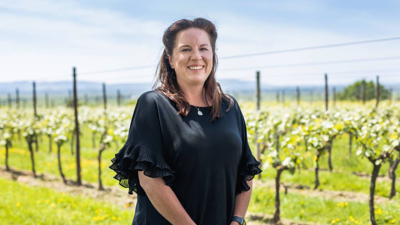 Henners winemaker Collette O'Leary stood in front of vines in their East Sussex vineyard in England