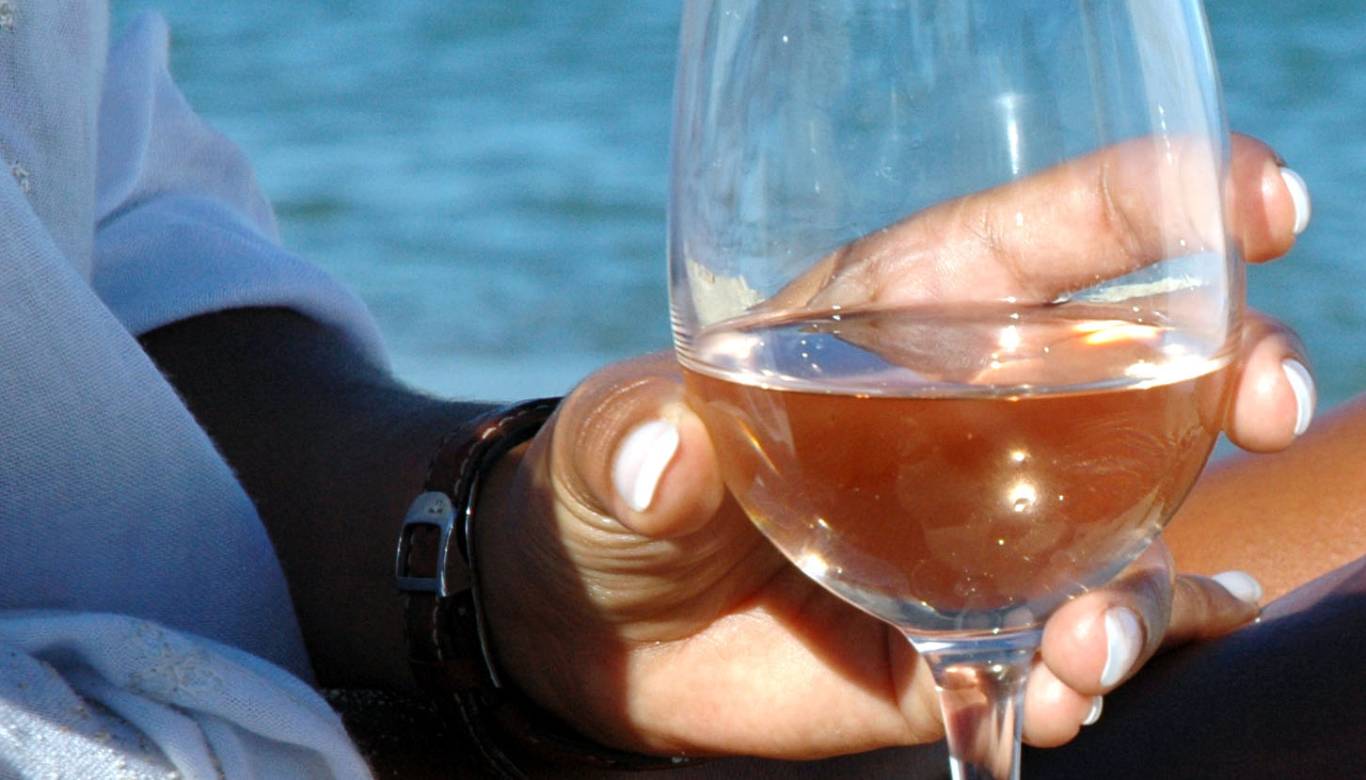 Closeup of a woman holding a glass of Provence rose