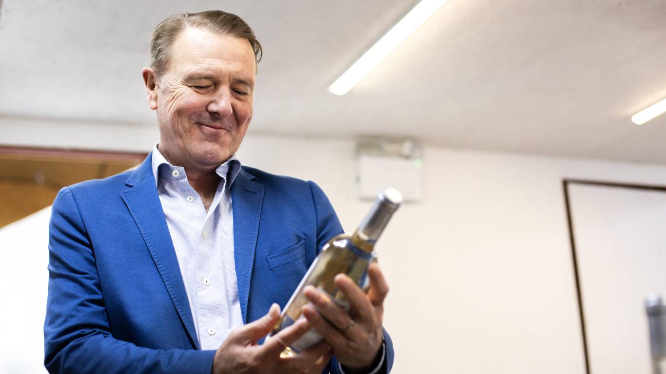 Phil Tufnell looking at a bottle of Tuffers' Tipple Bacchus 2020 and smiling