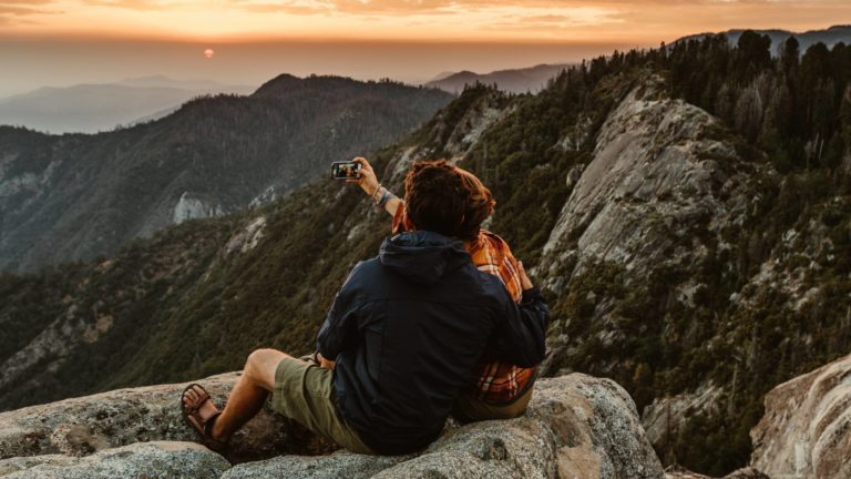 Two people taking a selfie on top of a mountain in Calfornia