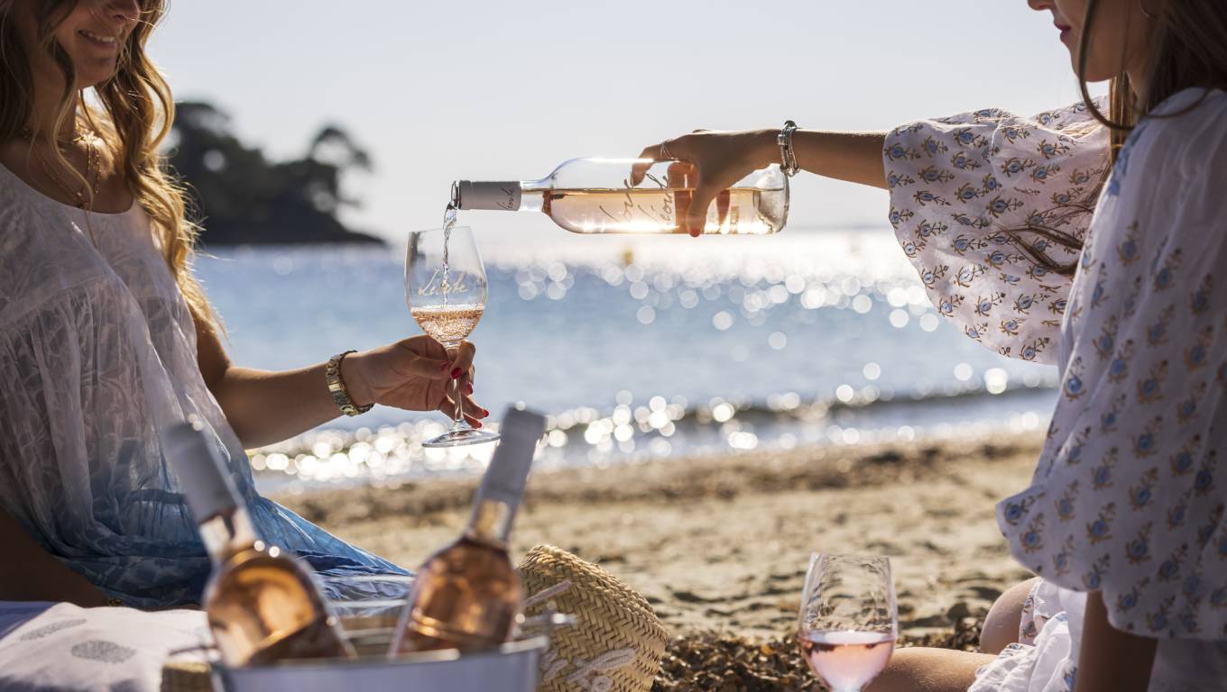 Two woman drinking Love by Leoube rose wine on the beach in Provence