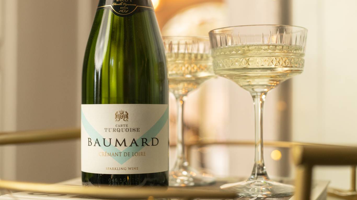 Bottle of Domaine Baumard Carte Turquoise Cremant de Loire NV on a gold drinks trolley with a glass of sparkling wine