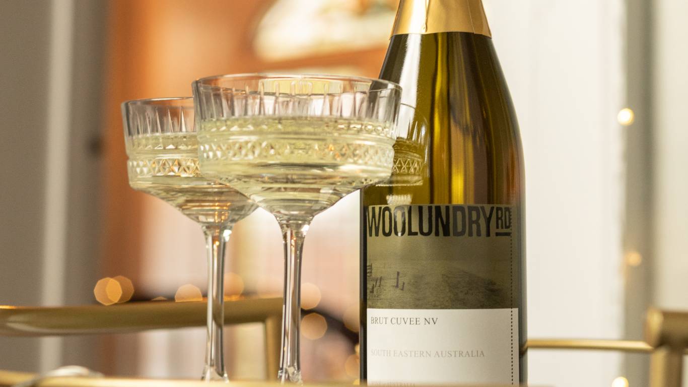 Bottle of Woolundry Road Sparkling South Australian Chardonnay Pinot Noir Brut NV on a gold drinks trolley with a glass of sparkling wine