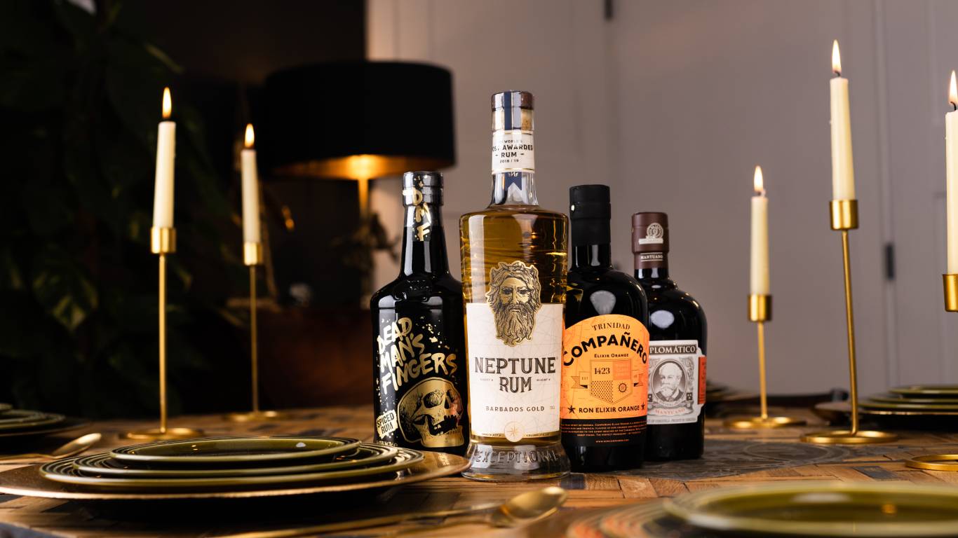 Photo of types of rum on a dining table with candles