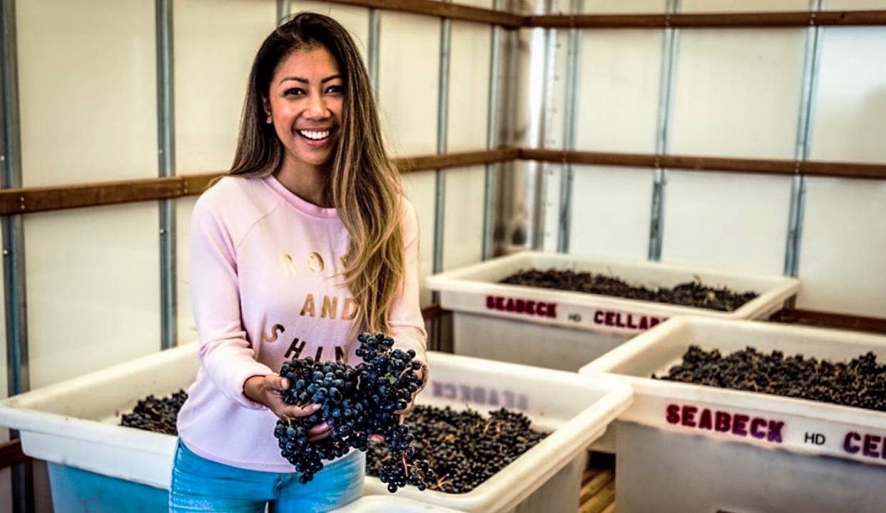 Ravynn Rants, co-owner of Seabeck Cellars in Washington, holding some grapes in the winery
