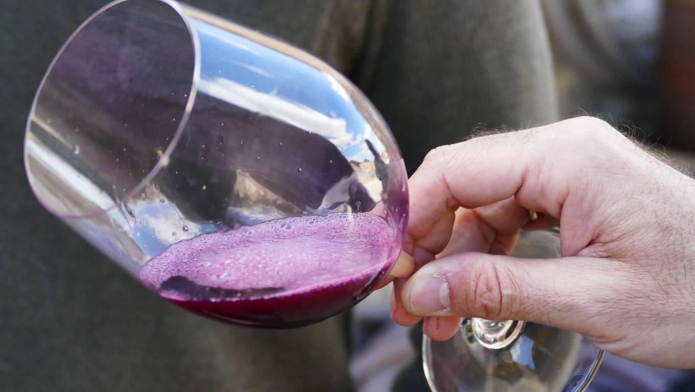 Close up of red wine in glass being held by hand