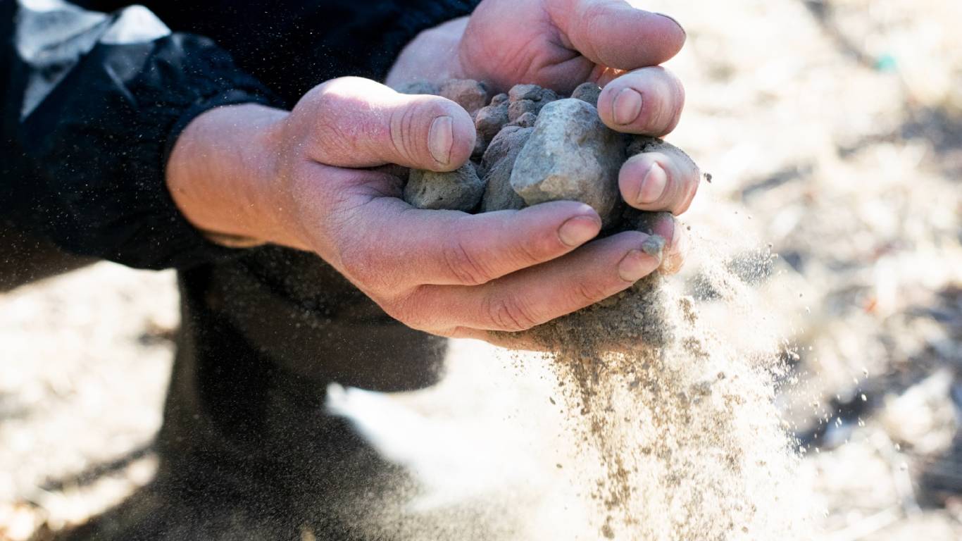 Close up of a man's hands holding stoney soil in a vineyard in Washington