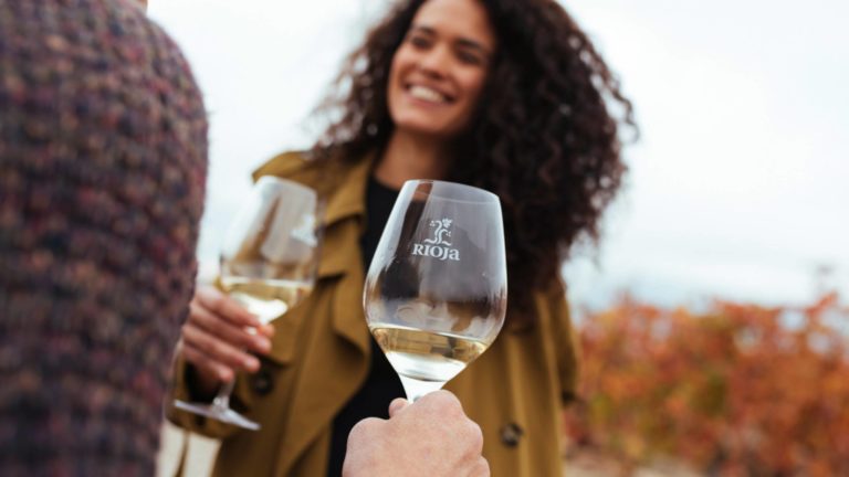 People holding glasses of white Rioja in a Rioja branded glass
