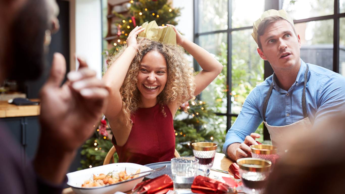 Group of friends laughing and enjoying Christmas dinner together