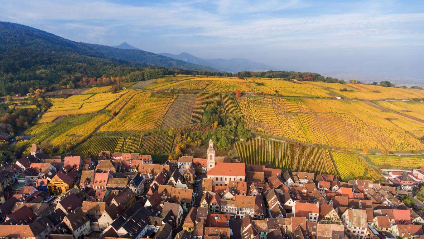 Ariel view of town in Alsace with rolling hills in the background