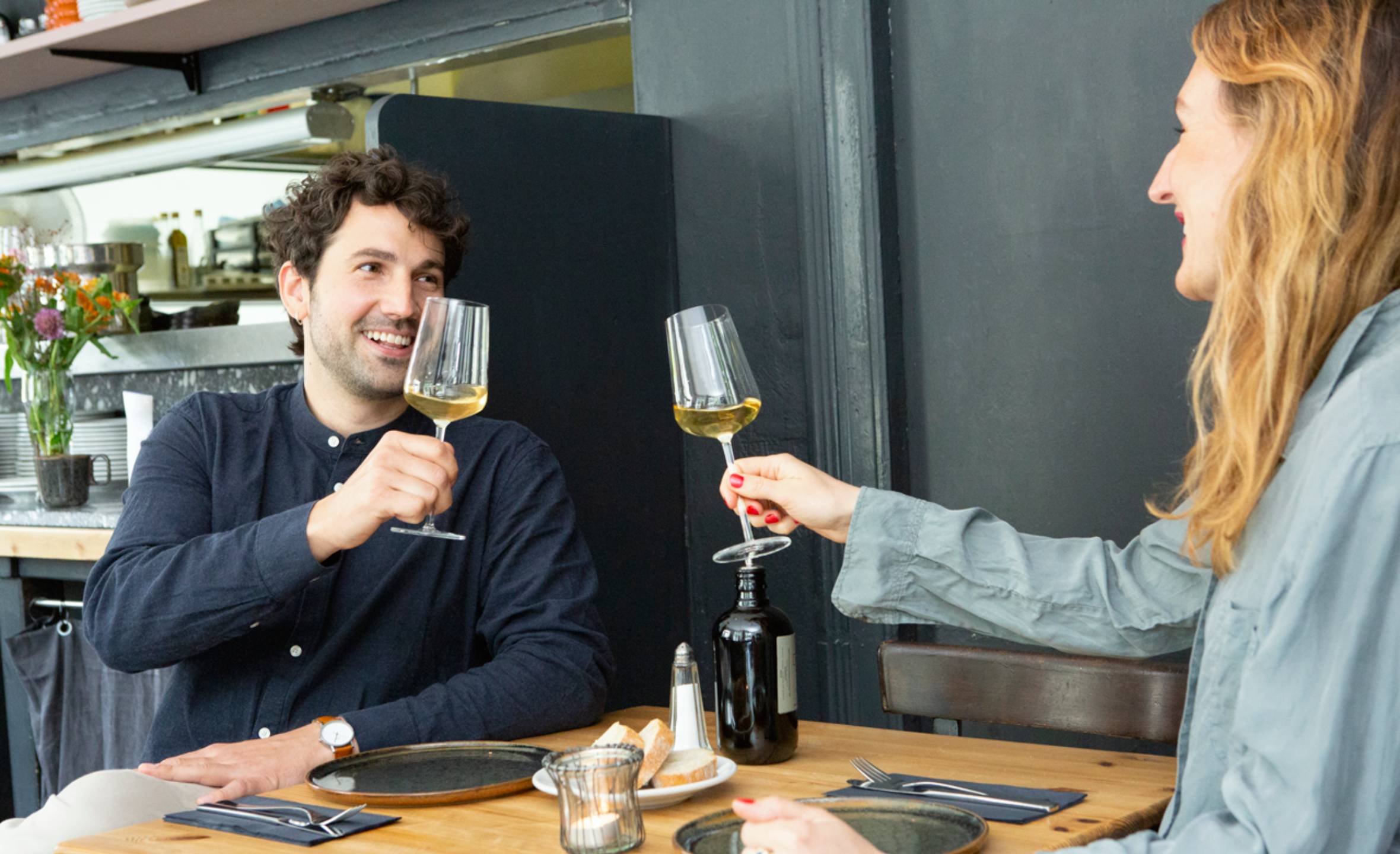 Two people drinking glasses of white wine