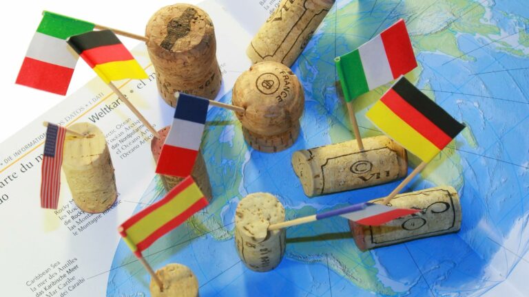 Several wine corks scattered on a world map with flags in them
