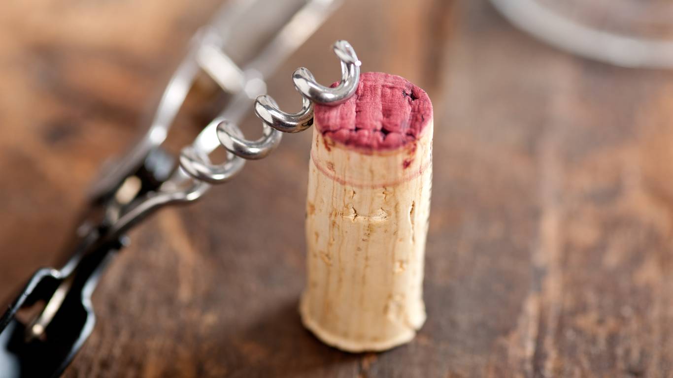 red wine cork next to a corkscrew