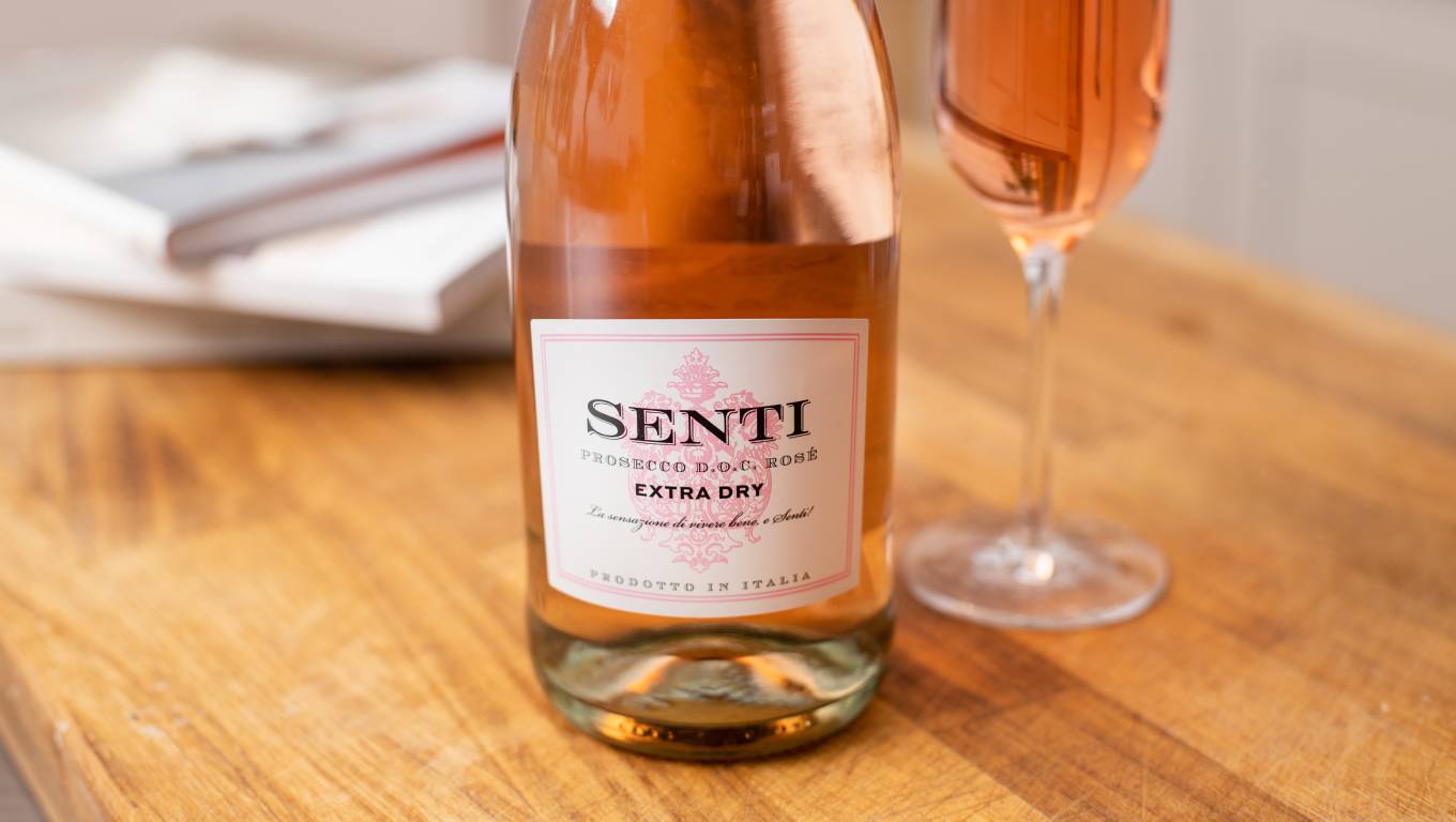A close up shot of Senti Prosecco Rosé bottle with a glass next to it