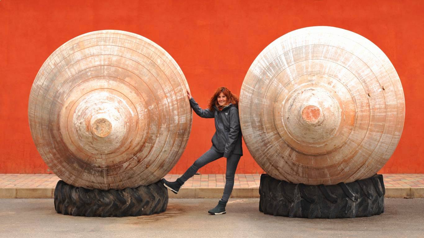 Sustainable winemaker Rosalia Molina of AltoLandon Winery standing between two giant clay amphora laying on their side