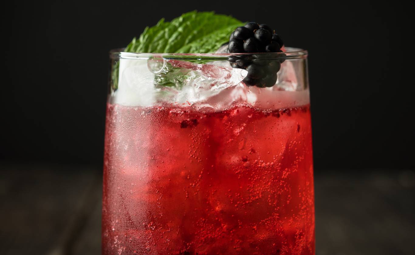 Close up of a Rosé Cooler cocktail over a dark background