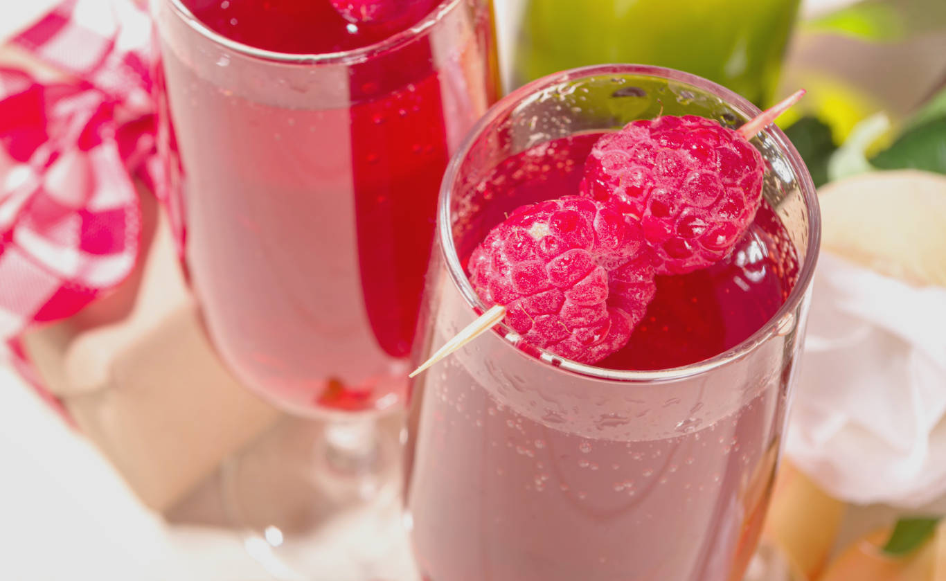 Close up of two Raspberry Mimosas over a white surface