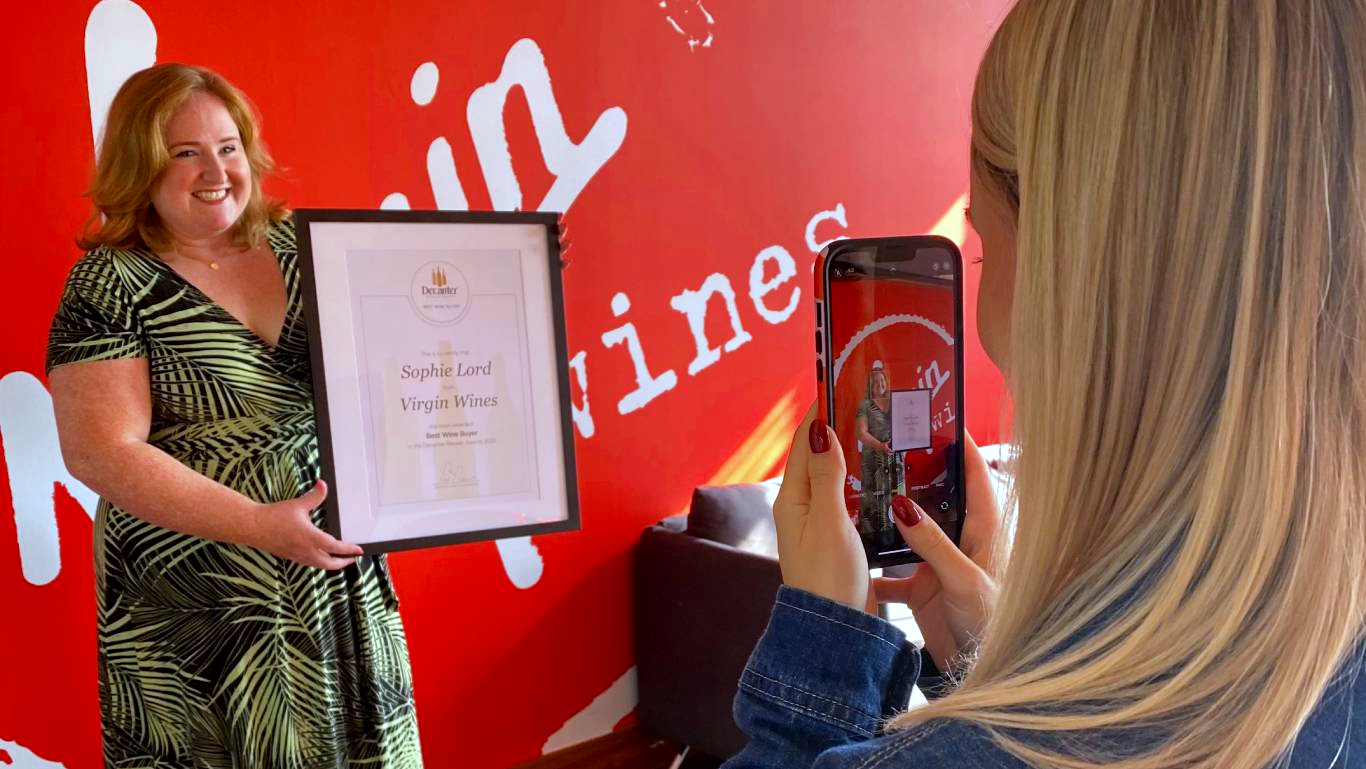 Photo of Head of Buying at Virgin Wines, Sophie Lord, holding up her Best Wine Buyer award from Decanter being photographed