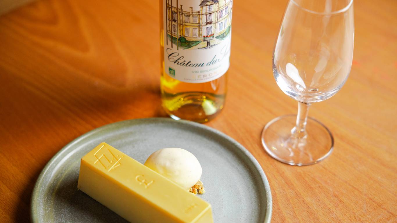 White chocolate cheesecake paired with dessert wine on a table