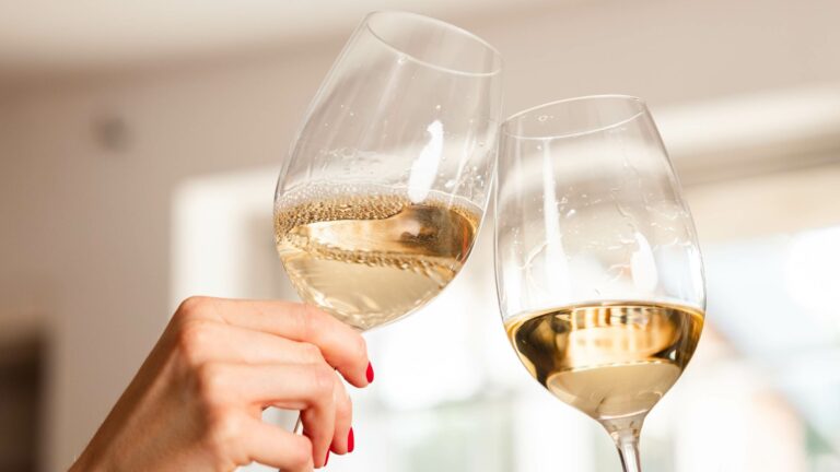 Two glasses of white wine where one has bubbles to represent faults in wine