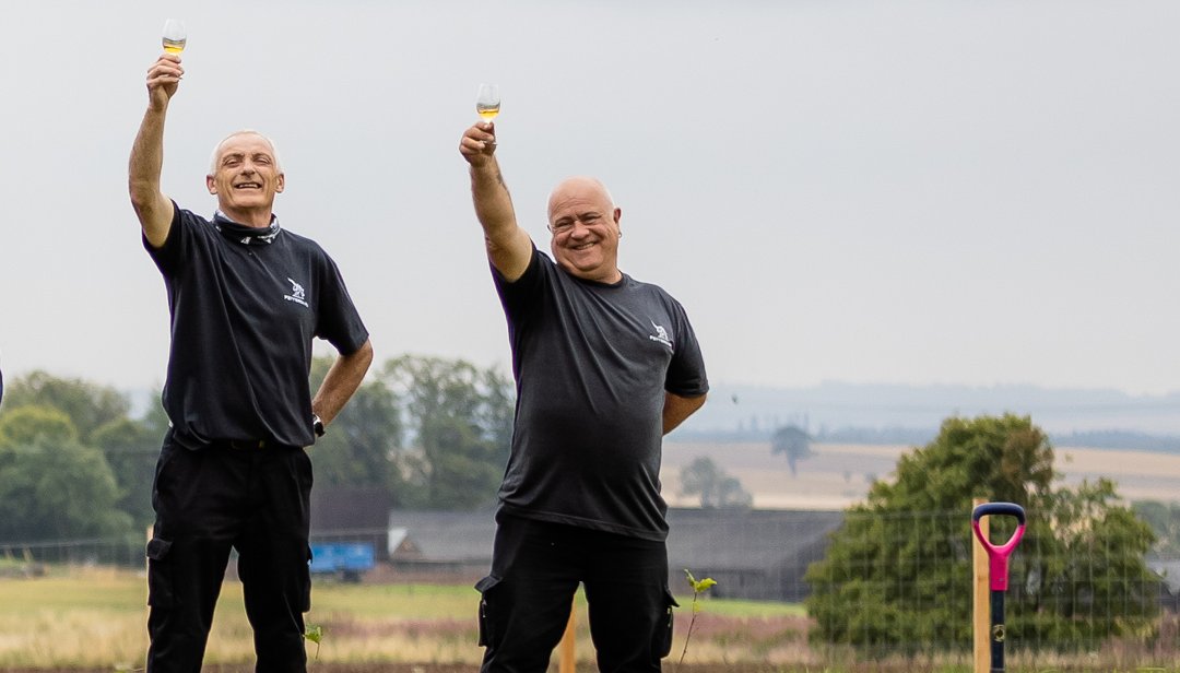 Team working at Fettercairn Distillery raising glasses of whisky in the air
