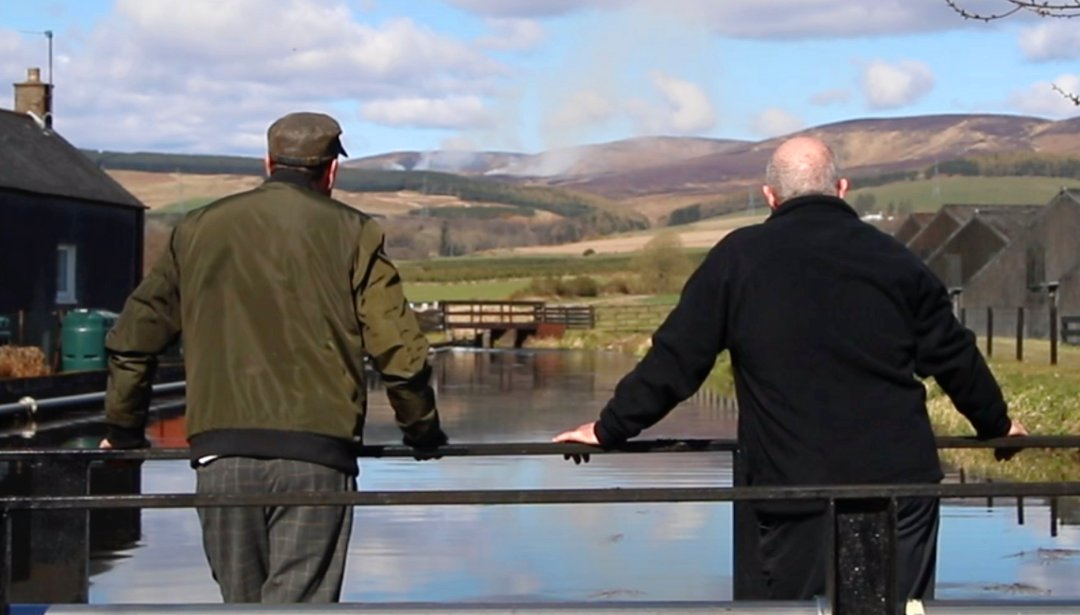 Two men looking out at water in Fettercairn village