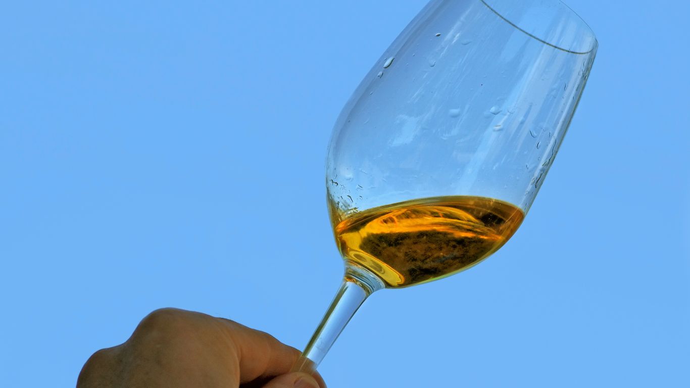 Man holding up a glass of Sauternes wine